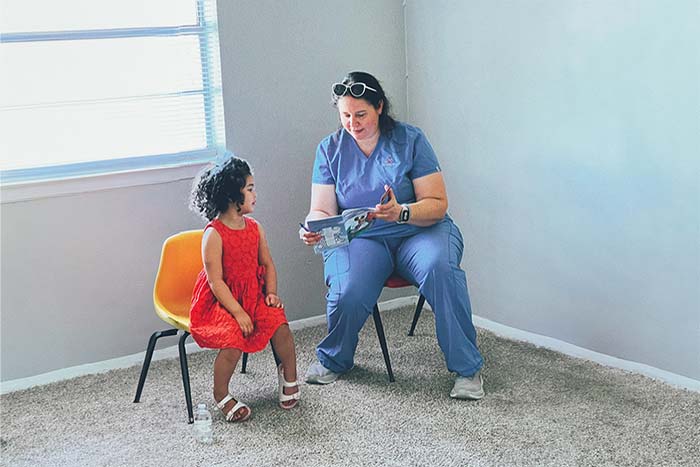Marissa Nurse Practitioner at Inspired Vision Compassion Center reading to young girl