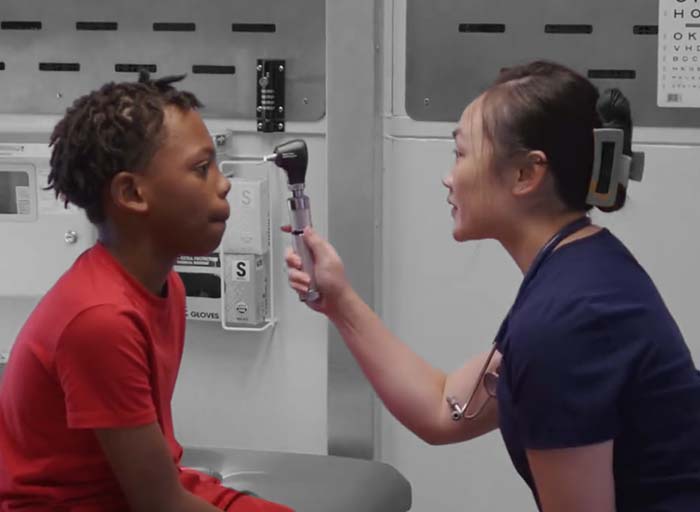 medical assistant giving young male an eye exam